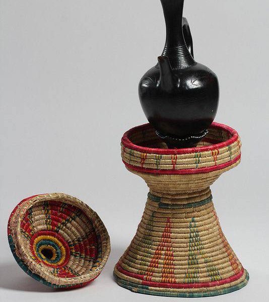 A traditional Ethiopian clay pot known as jebena, placed on a a mesob -a traditional platter used to serving food and drinks in Ethiopian culture.